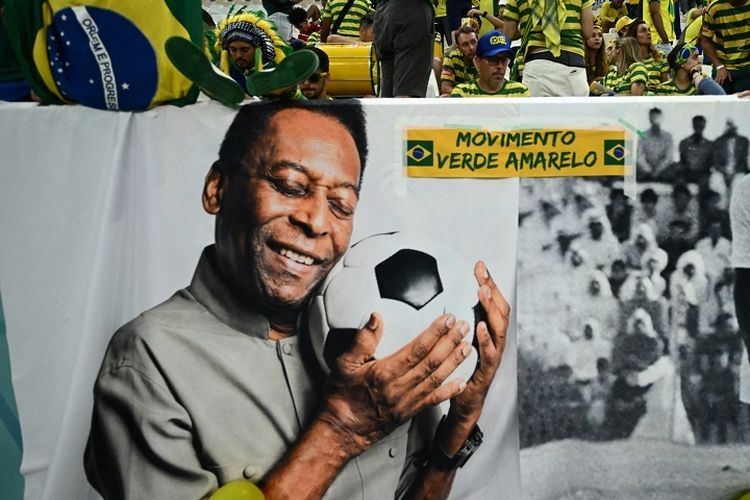 Legenda Brasil Pele ditampilkan di spanduk besar dekat kerumunan penonton saat pertandingan Grup G Piala Dunia 2022 Kamerun vs Brasil di Stadion Lusail, Qatar, 2 Desember 2022. Pele tengah menjalani perawatan di RS di Sao Paolo karena masalah pernapasan. Pele meninggal dunia dalam usia 82 tahun pada Jumat (30/12/2022) dini hari WIB.(AFP/JEWEL SAMAD)