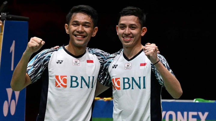 Fajar Alfian dan Muhammad Rian Ardianto berpose setelah mengalahkan Mohammad Ahsan dan Hendra Setiawan dari Indonesia dalam pertandingan final ganda putra di turnamen bulu tangkis Malaysia Masters di Kuala Lumpur, Minggu (10/7/2022). Foto: Mohd Rasfan/AFP